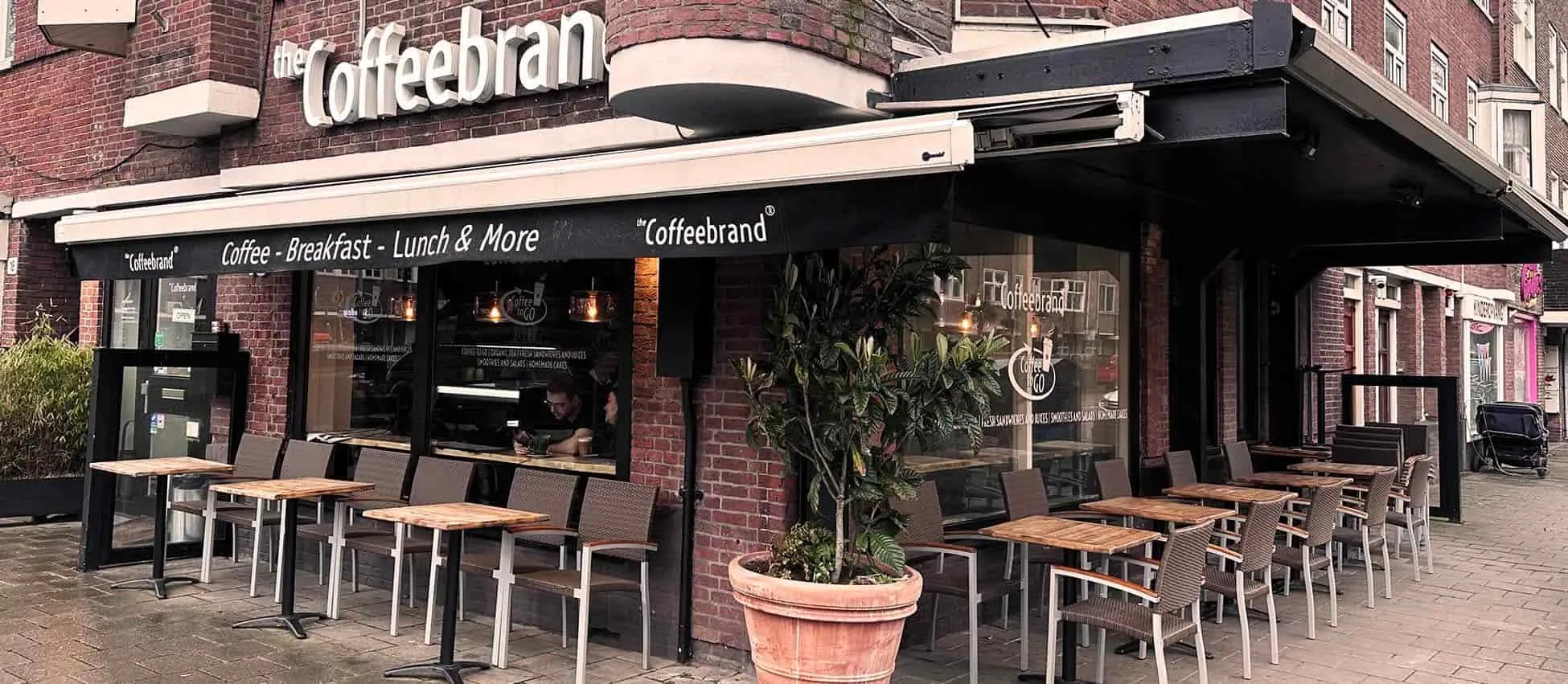 Restaurant met grote glazen puien en terras in Amsterdam